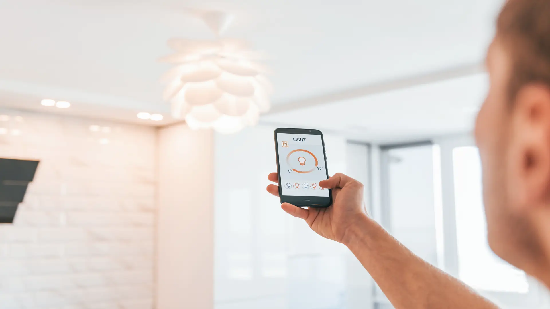 Adult man holding phone controlling lighting