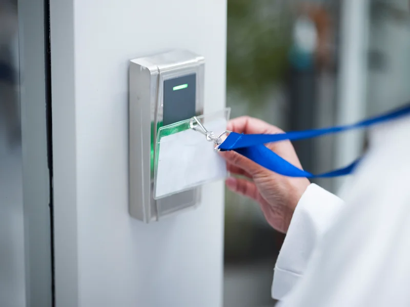 Hand using key card for security door entrance