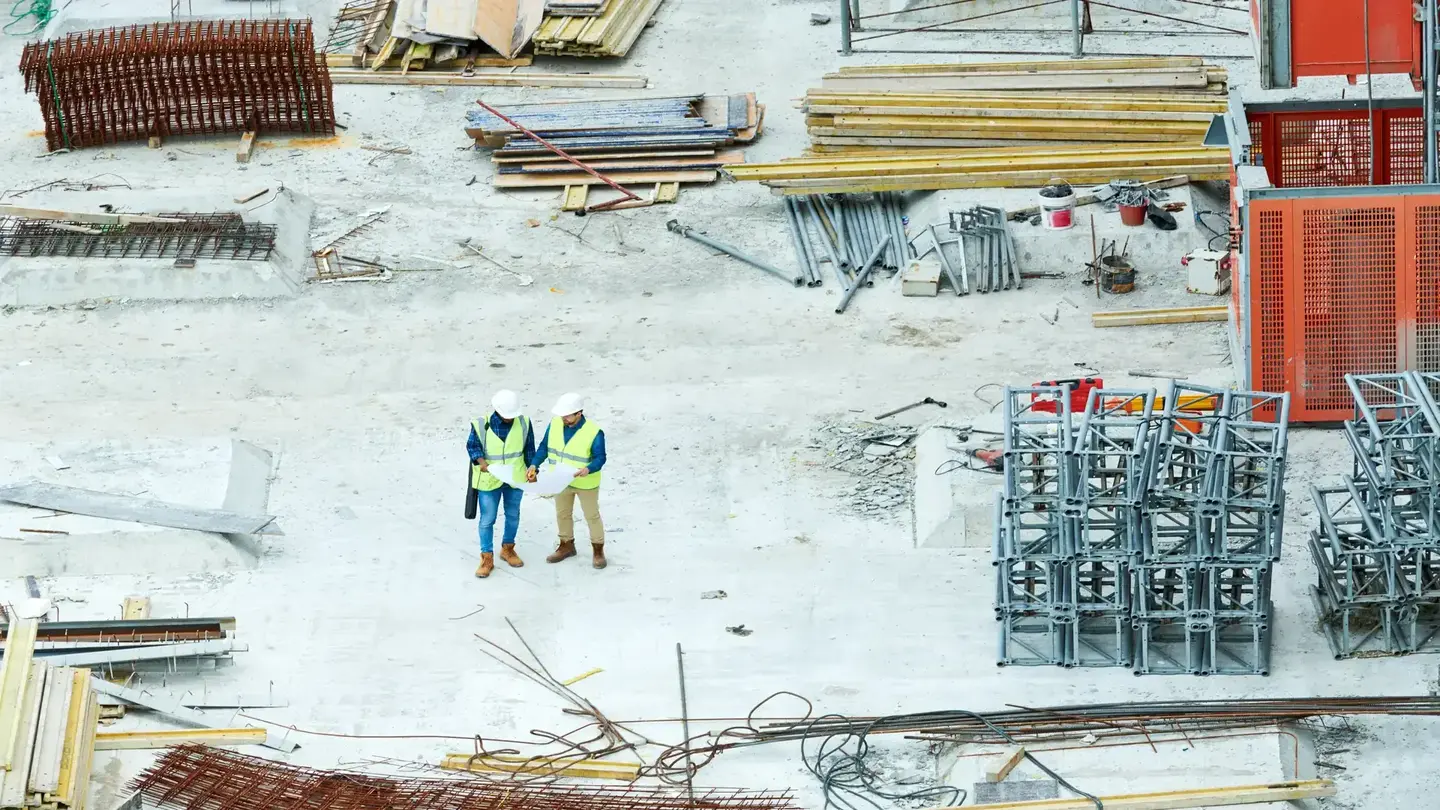Building inspectors reading blueprint on construction site